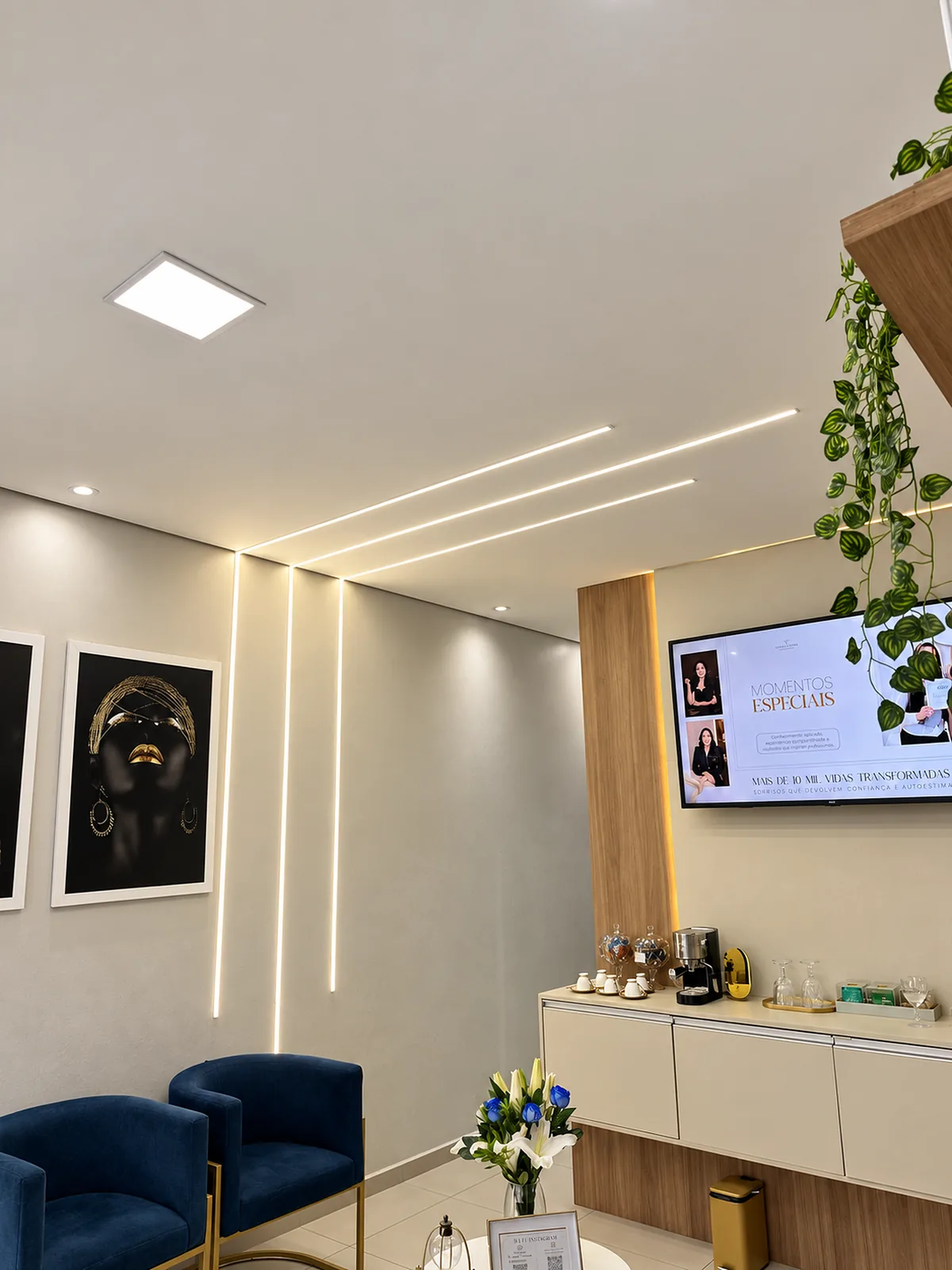 Ambiente de espera com iluminação embutida, quadros e plantas