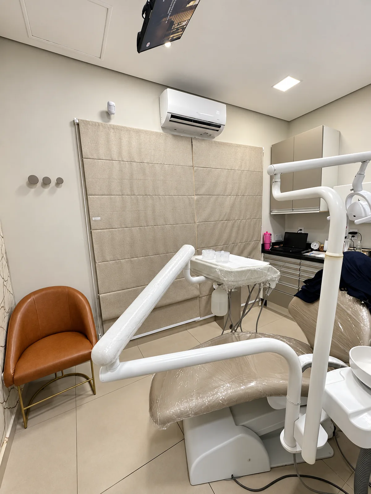 Consultório odontológico com cadeira, refletor e equipamentos